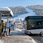 Ski bus zatrzymuje się przy ośnieżonym przystanku obok stoku w Austrii.
